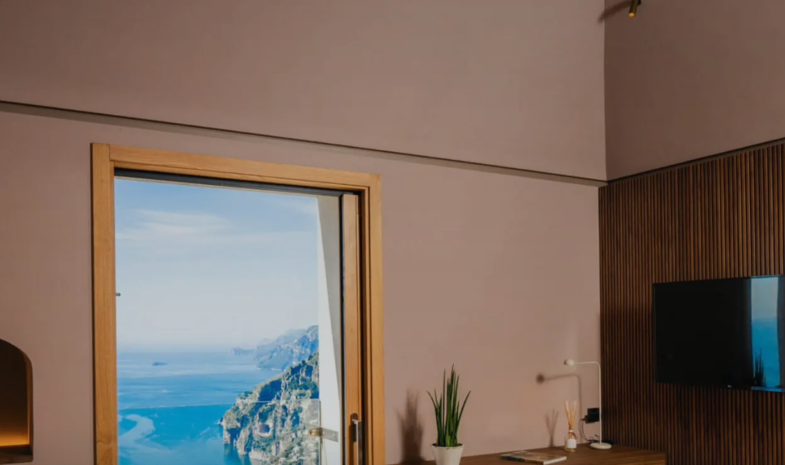 A guest room above Positano with the coast through the doorway