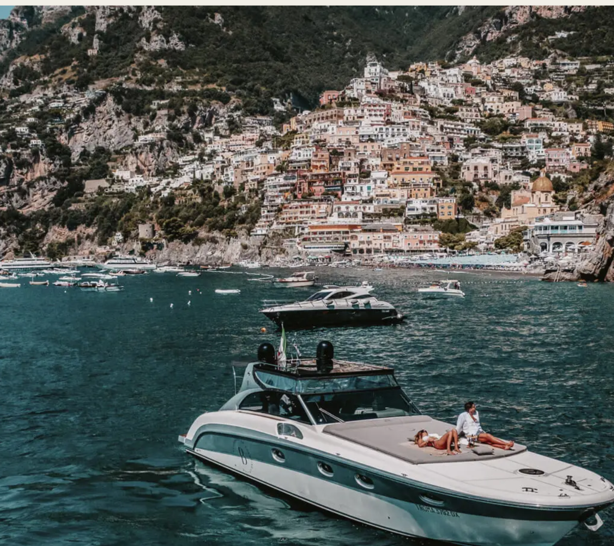 A tender anchored off Positano, the town rising from the water behind it